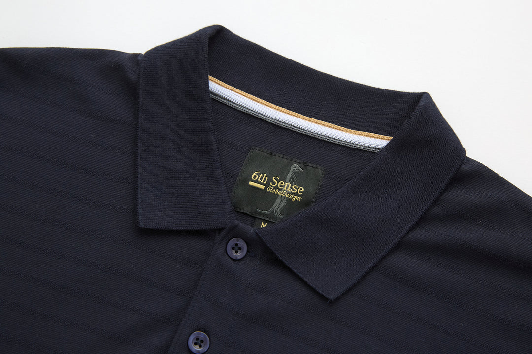Dark navy polo shirt collar with branded neck label and button close-up