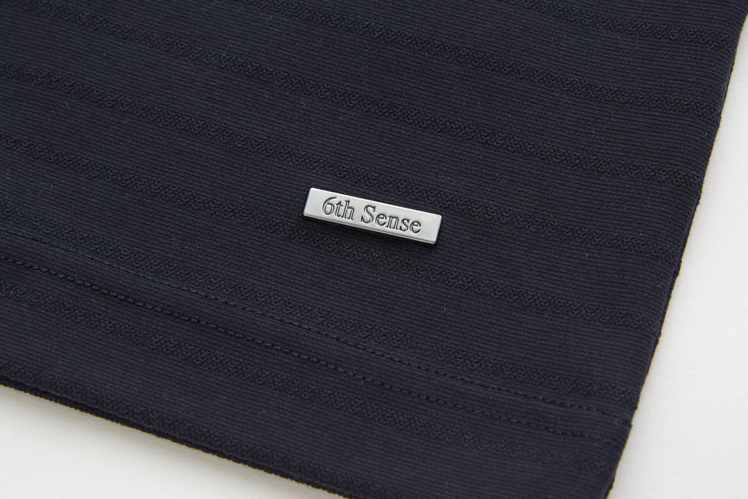 Dark navy polo shirt hem with 6th Sense woven label