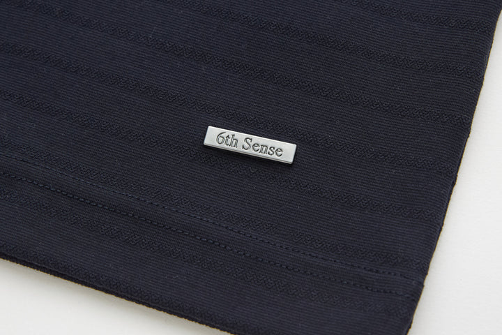 Dark navy polo shirt hem with 6th Sense woven label