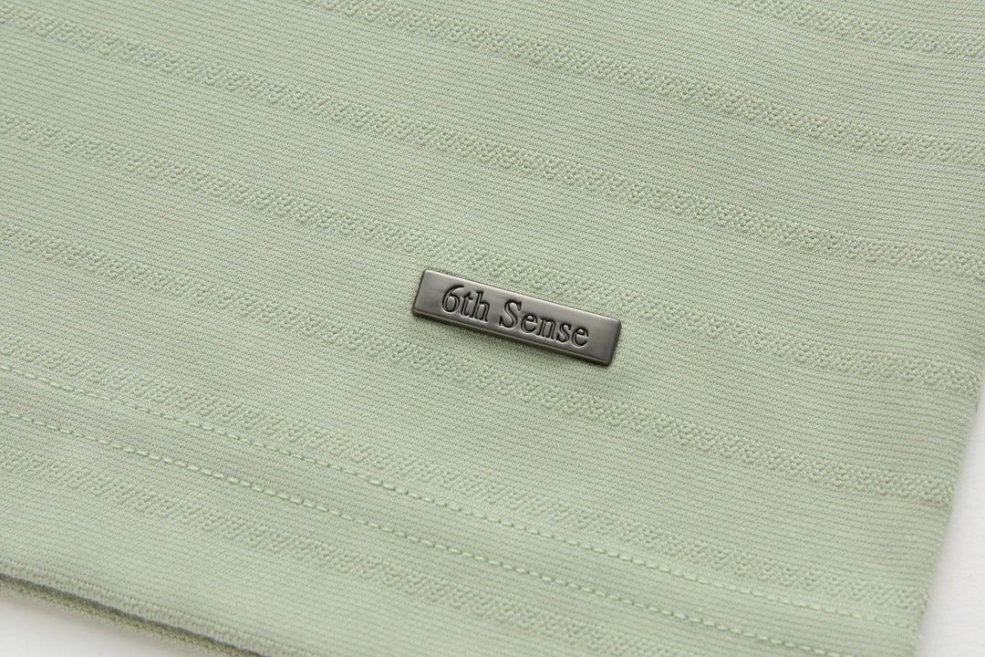Sage polo shirt back hem with 6th Sense logo tab