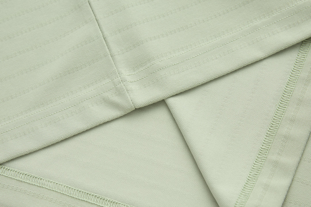 Sage polo shirt flat lay showing fabric weave and side seam