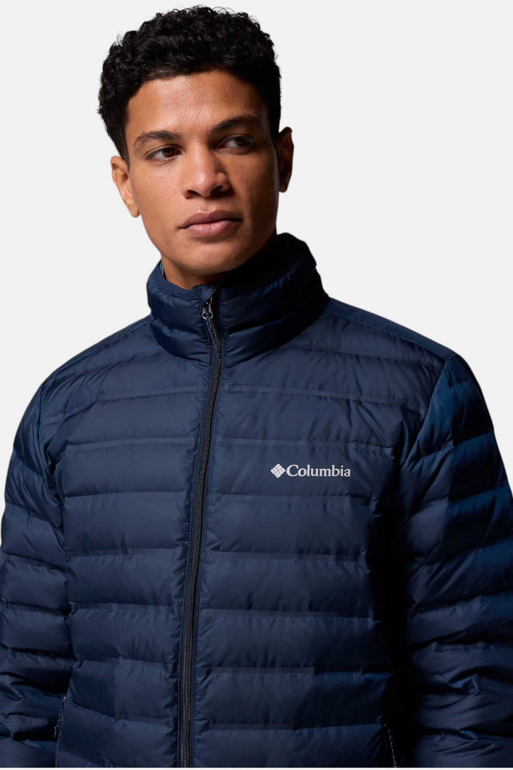 Men's navy down puffer jacket close-up with stand collar and Columbia logo badge
