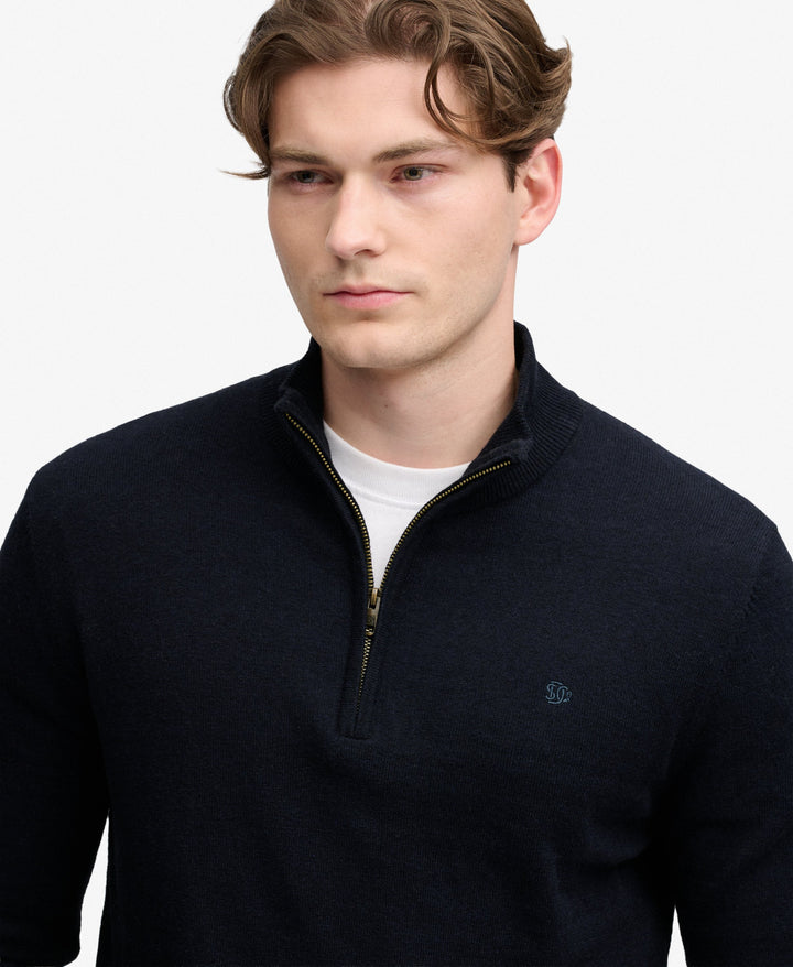 Navy half-zip sweater close-up with stand collar and small chest logo