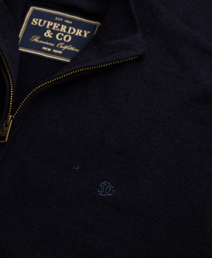 Navy half-zip sweater collar label close-up with gold zipper trim