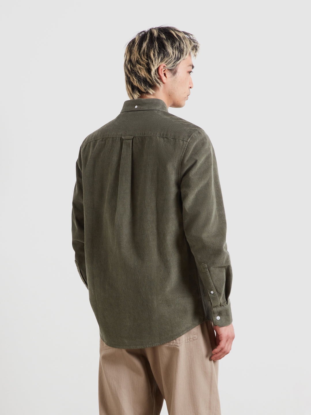 Long-sleeve button-down shirt in dark green corduroy, back view with yoke seam