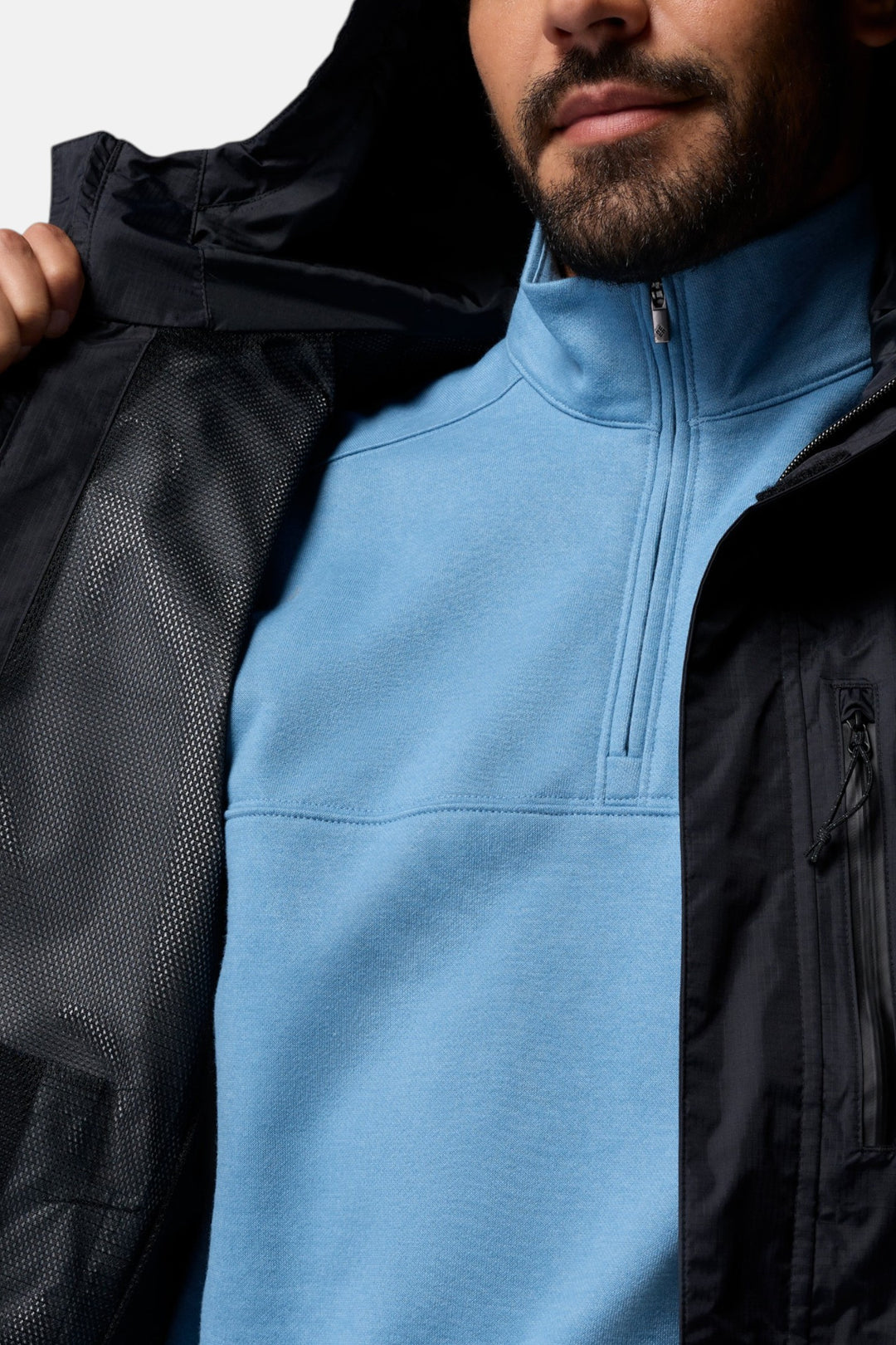 Men's jacket interior view with light blue zip lining and black outer fabric
