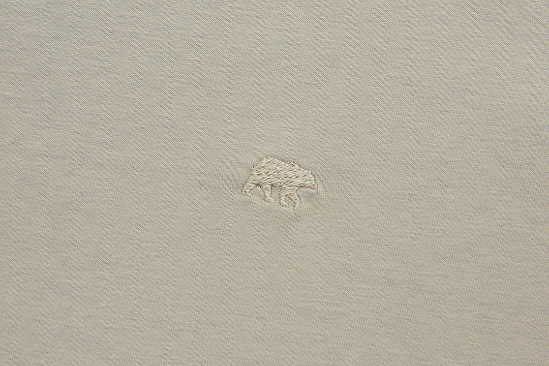 Beige polo shirt with small shark logo on left chest