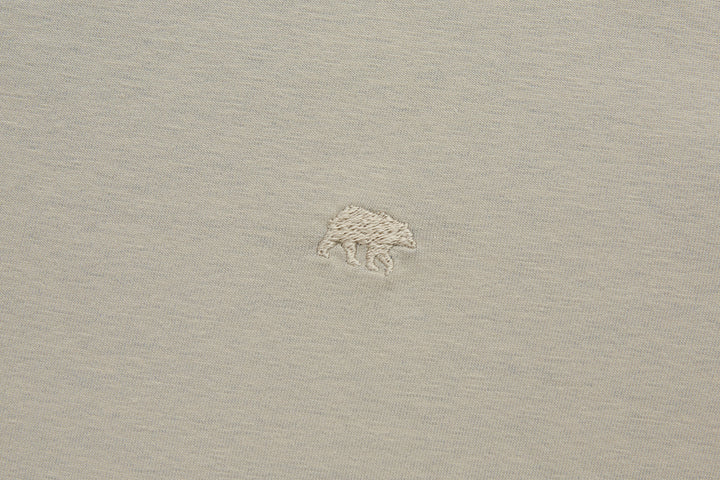 Beige polo shirt with small shark logo on left chest