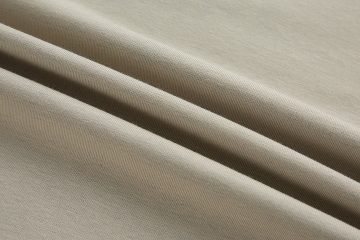 Beige polo shirt fabric close-up with fine knit texture