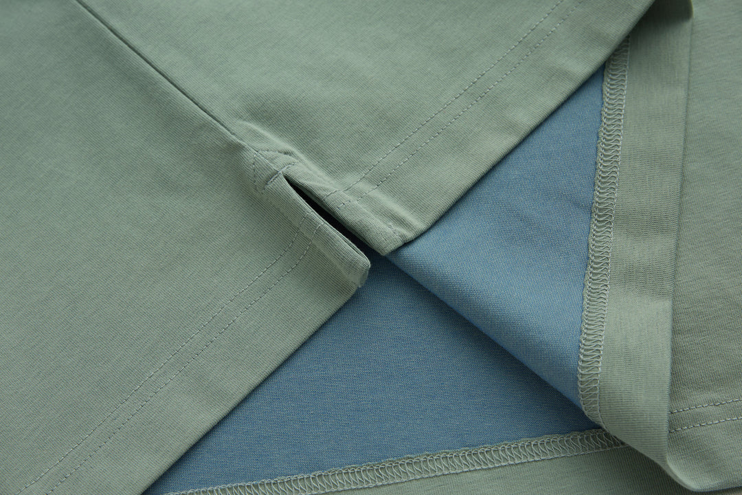 Mint polo shirt sleeves and hem seam detail with visible stitching