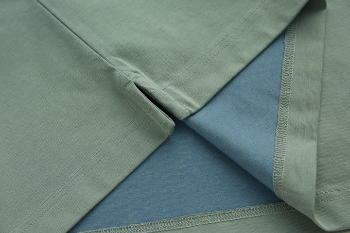 Mint polo shirt sleeves and hem seam detail with visible stitching
