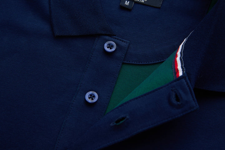 Navy polo shirt placket open to show green inner panel and tricolor trim