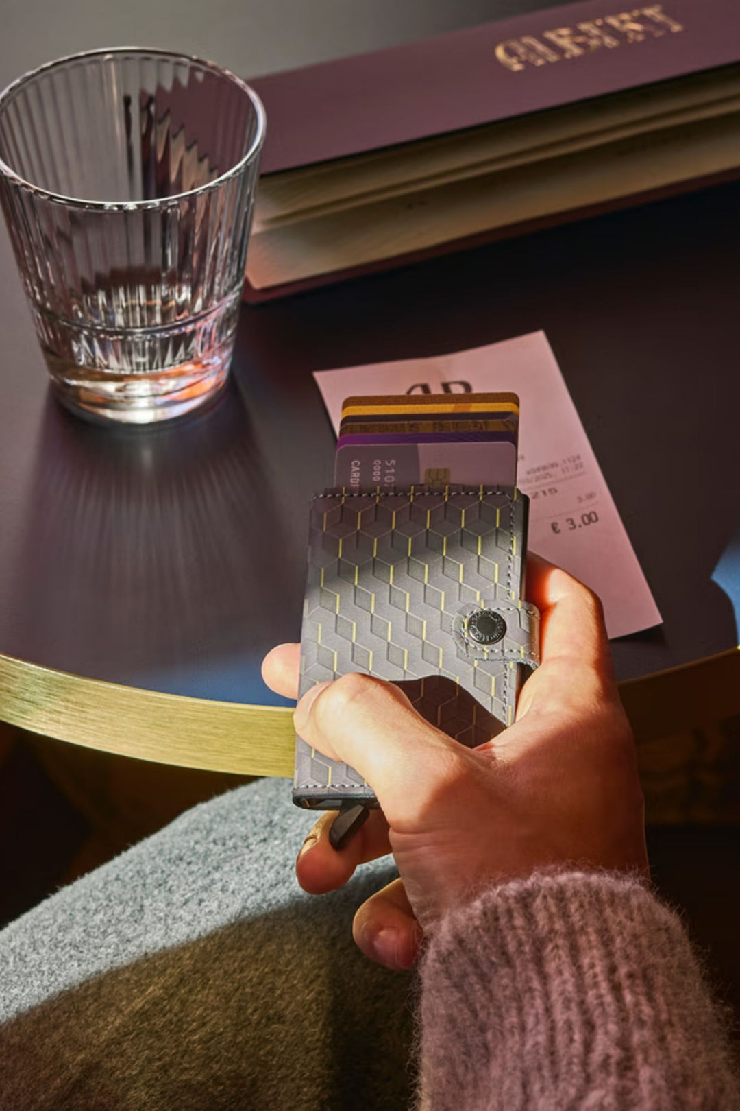 Card wallet held by hand, open to reveal a card slot with geometric design.
