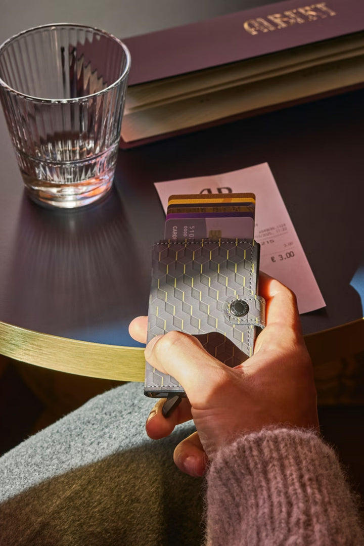 Card wallet held by hand, open to reveal a card slot with geometric design.
