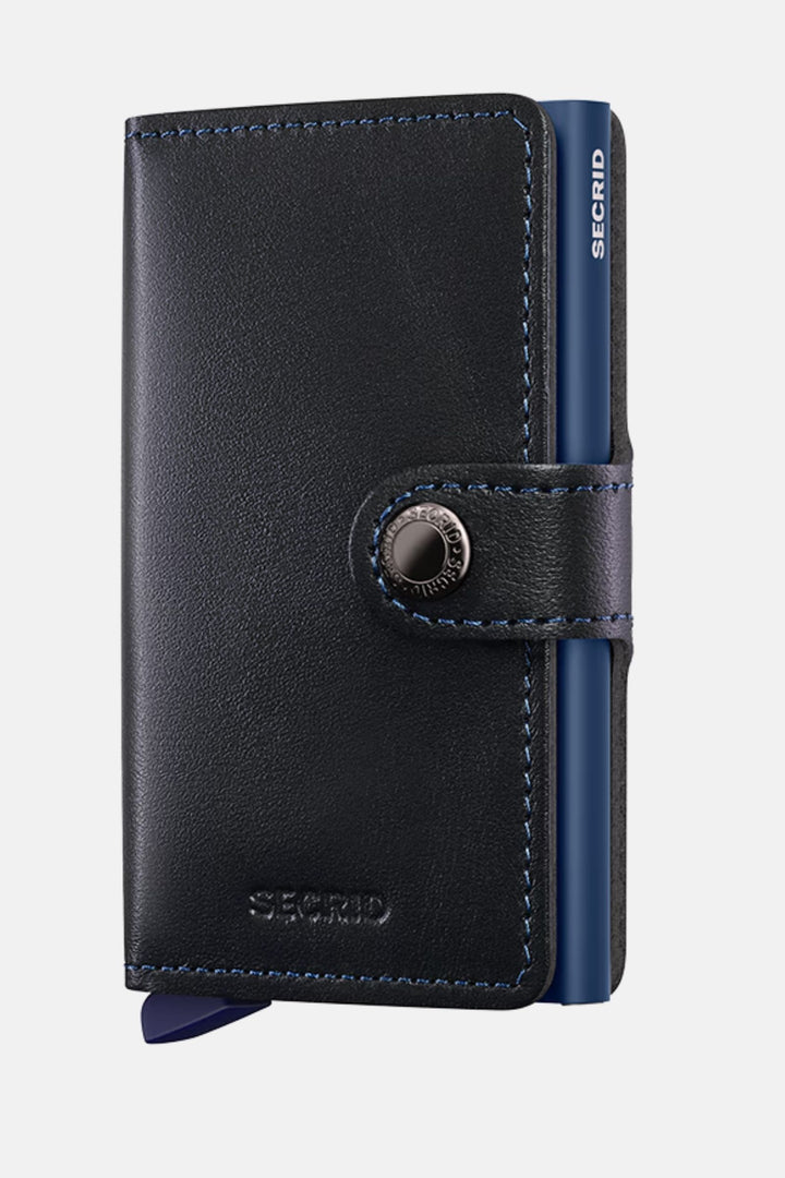 Secrid mini wallet in black leather with navy side panel and round button closure