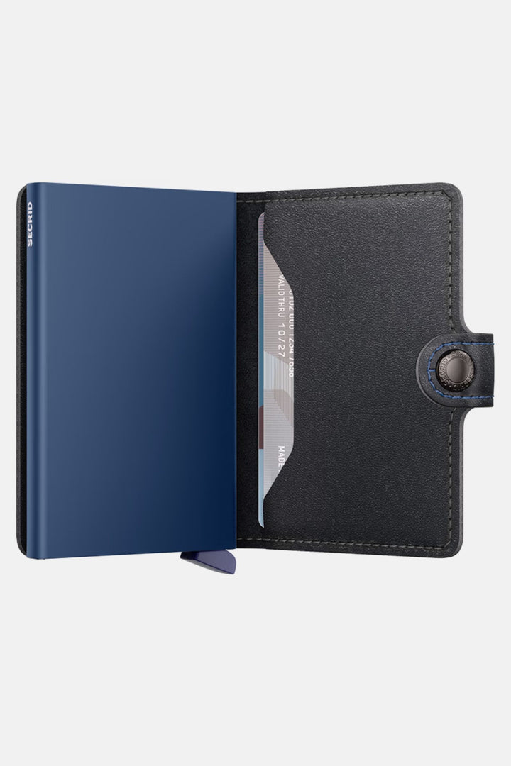 Secrid mini wallet open: black cover with navy lining and card window section