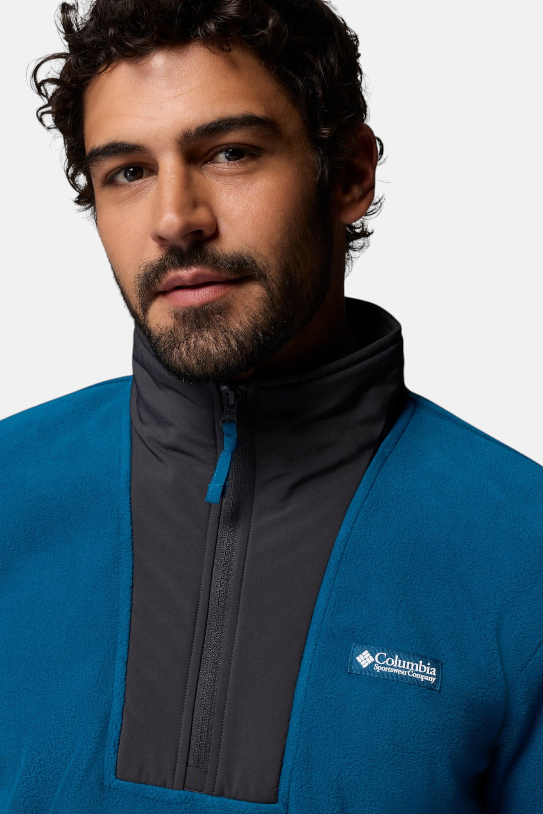 Half-zip fleece pullover close-up with dark gray zipper placket and chest logo