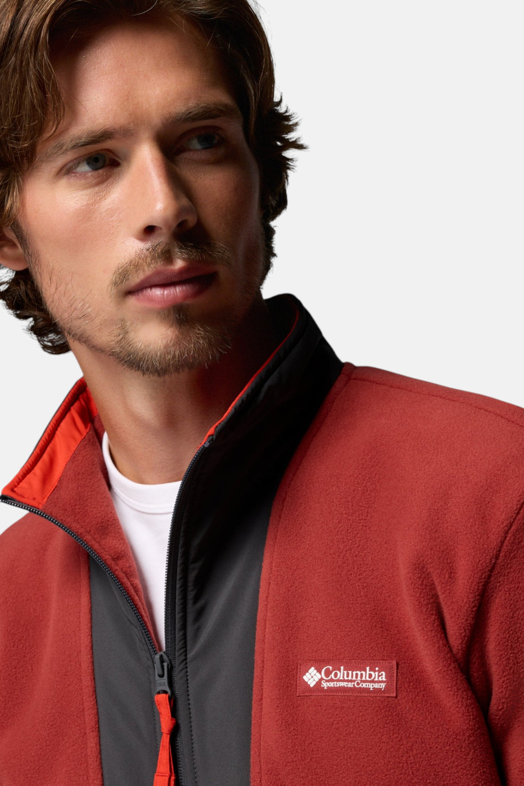 Columbia fleece full-zip jacket close-up in red oxide with logo patch and orange zipper
