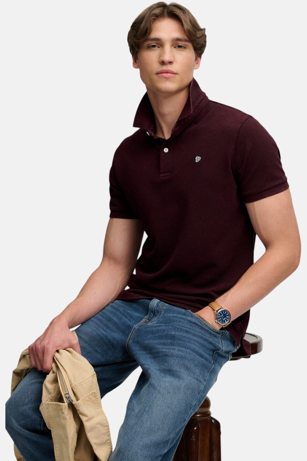 Superdry maroon polo shirt, side-front view, button collar and chest logo