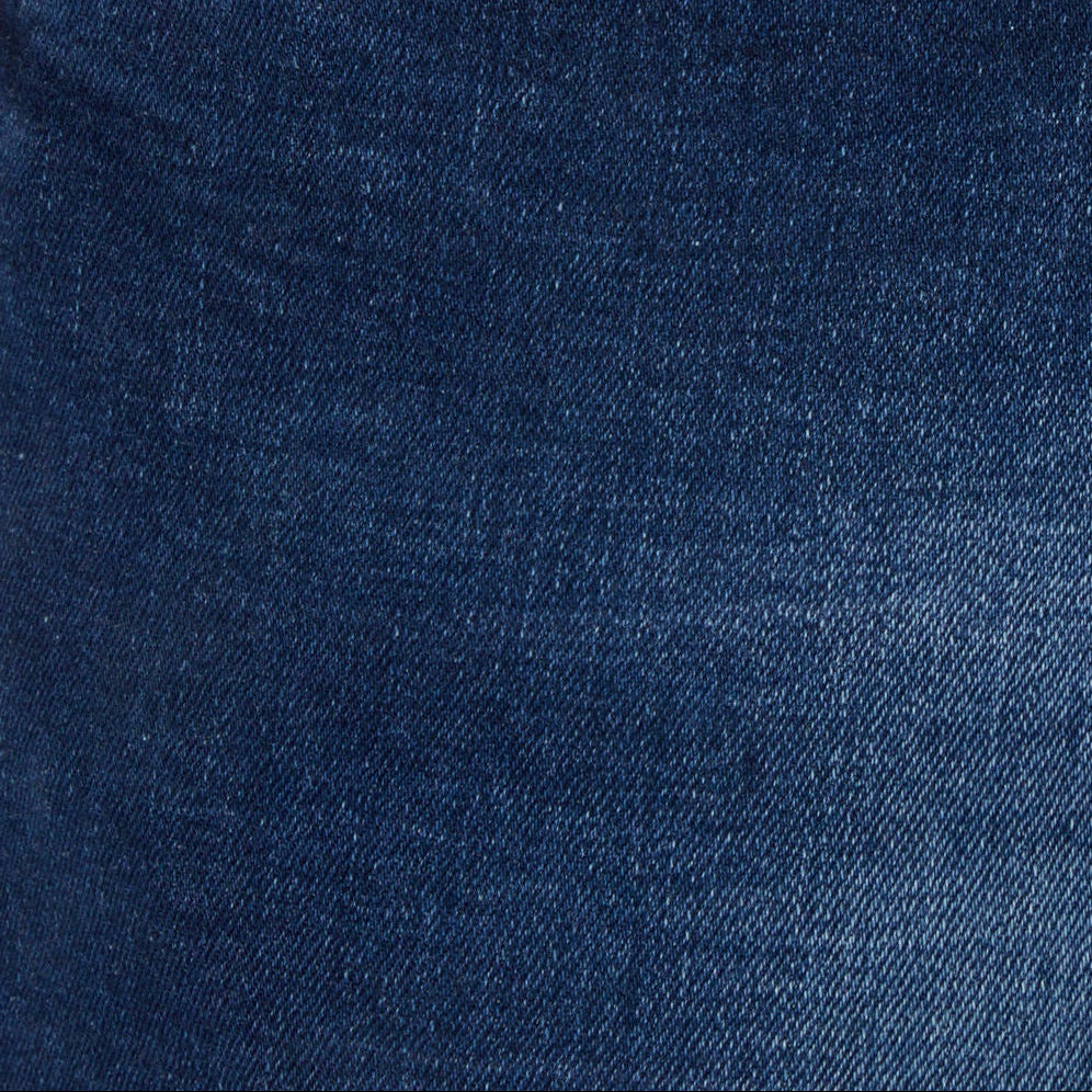 Blue denim jeans pocket close-up with stitched seams and leather logo patch
