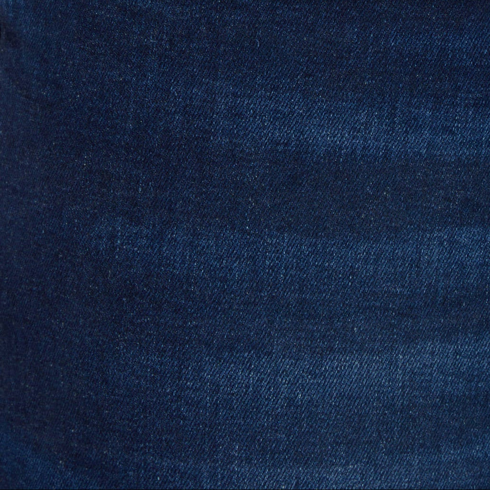 Front pocket and seam detail on dark blue jeans with tan rivets